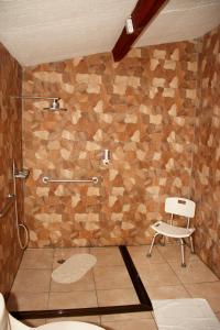 a bathroom with a shower and a white chair at Hotel Samoa del Sur in Golfito