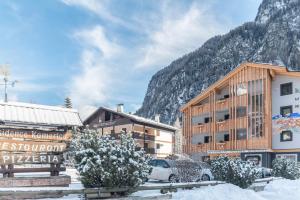 un hôtel dans les montagnes avec de la neige au sol dans l'établissement Residence Kamerloy G, à Campitello di Fassa