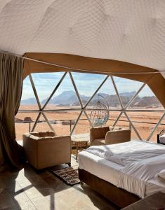 Schlafzimmer mit einem Bett und Blick auf die Wüste in der Unterkunft Hasan Zawaideh Camp in Wadi Rum