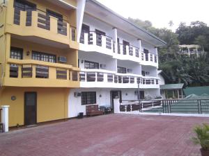 a yellow and white building with a lot of windows at Seashore Beach Resort in Puerto Galera