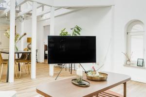 360 Grad Hotel & Bar في لير: غرفة معيشة مع تلفزيون بشاشة مسطحة على طاولة