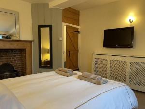 a bedroom with a bed with two towels on it at Smuggler's Cottage in Deal