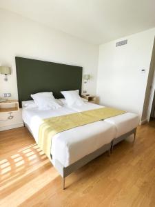 a bedroom with a large bed with a green headboard at FAY Victoria Beach in Rincón de la Victoria