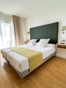 a bedroom with a large bed with a green headboard at FAY Victoria Beach in Rincón de la Victoria