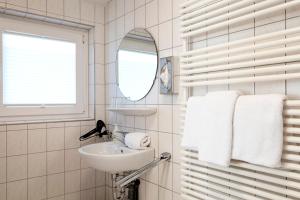 a bathroom with a sink and a mirror and towels at Helgolandia Dependance in Helgoland