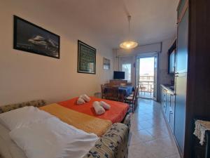 a bedroom with a bed and a kitchen with a table at [Loano Centro] Vista aperta nel cuore del Paese in Loano