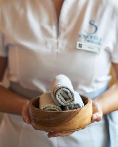 une femme tenant un bol en bois rempli de serviettes dans l'établissement SANA Malhoa Hotel, à Lisbonne