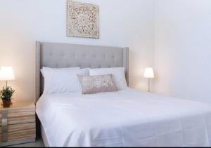 een slaapkamer met een groot wit bed met 2 lampen bij Incredible 3BR Townhouse In Miami in Golden Glades