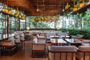 een restaurant met tafels, stoelen en planten bij SANA Malhoa Hotel in Lissabon