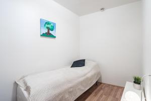 a white bedroom with a bed and a picture on the wall at RVK City centre apartment in Reykjavík