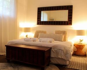 a bedroom with a large bed with a mirror on the wall at ALLURING SELF CATERING 2 BEDROOM VILLA at BOKMAKIERIE VILLAS in Windhoek