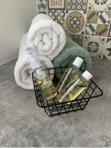 a basket with soap and towels in a bathroom at Adorable F1, au bord du lac d’élancourt village in Élancourt