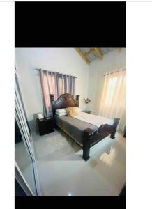 een slaapkamer met een bed met een houten hoofdeinde bij Oasis de Paz 2.1 in Jarabacoa