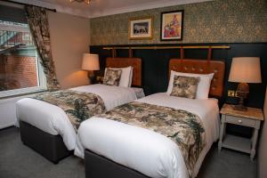 1 dormitorio con 2 camas y ventana en The Red Lion Inn by Chef & Brewer Collection en Todwick