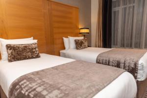 um quarto de hotel com duas camas e uma janela em Tara Lodge em Belfast