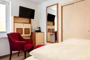 um quarto com uma cama, 2 cadeiras e um espelho em Helgolandia Dependance em Helgoland