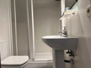 Baño blanco con lavabo y aseo en THC Bergantin Hostel en Madrid