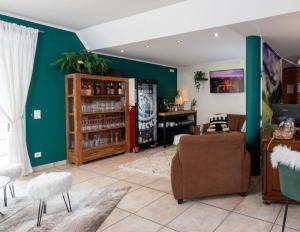 a living room with green walls and a couch and chairs at allgovia hotel garni in Wangen im Allgäu