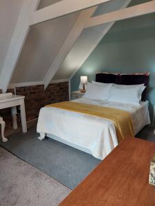 een slaapkamer met een groot bed op zolder bij Kimi's Cottage in Simondium