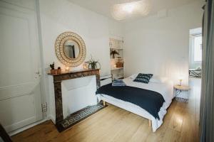- une chambre avec un lit, une cheminée et un miroir dans l'établissement L'Alma16:Jardin, centre ville, belles prestations, à Cherbourg en Cotentin