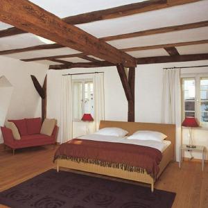 a bedroom with a large bed and a red couch at Poststation Zum Alten Forstamt in Morschen