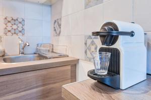 a juicer with a glass on a counter in a kitchen at Aux portes de Paris , un 3 pcs bien aménagé in Nogent-sur-Marne