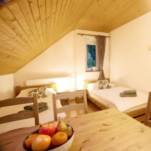 um quarto com duas camas e uma tigela de fruta numa mesa em Apartmány Bramborka em Janov nad Nisou