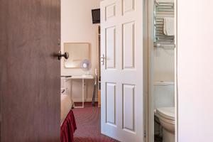 an open door to a bathroom with a toilet at City Centre Guest House in Gloucester