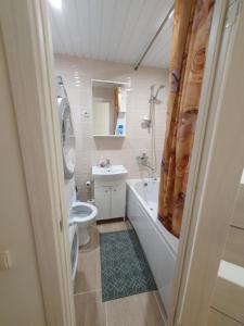 łazienka z wanną, toaletą i umywalką w obiekcie Dainai 1-Bedroom apartament. w Szawlach