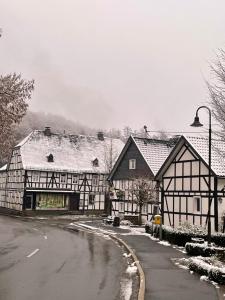 two black and white buildings with snow on the ground at Gästehaus Sille in Morsbach - Holpe in Morsbach