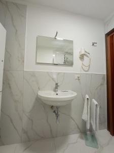 a white bathroom with a sink and a mirror at Relais Duomo Adelaide in Florence