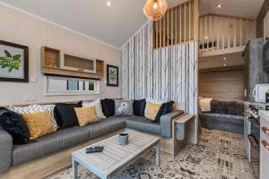 uma sala de estar com um sofá e uma mesa em The Escape - Luxury Pod Close to Beach em Amroth