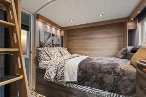 Cama en habitación con pared de madera en The Escape - Luxury Pod Close to Beach en Amroth