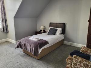 a bedroom with a large bed and a chair at Carlton Hotel in Forres