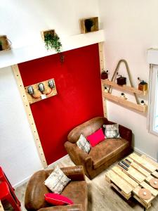 a living room with a red accent wall andbrown furniture at Duplex industriel - Centre ville Parking privé WIFI in Angers