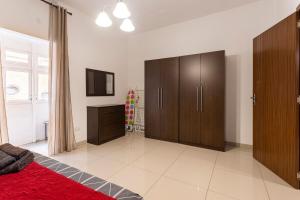 een slaapkamer met een bed en een houten kast bij Superbly Located Cosy 2-Bedroom Apartment Valletta in Valletta