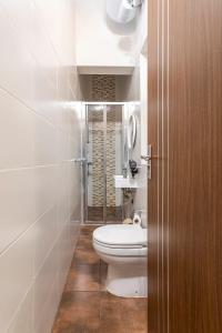 a small bathroom with a toilet and a shower at Superbly Located Cosy 2-Bedroom Apartment Valletta in Valletta +13 photos