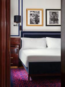 sypialnia z łóżkiem i obrazami na ścianie w obiekcie Casa Cipriani Milano w Mediolanie