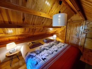 a bedroom with a bed in a log cabin at Gîte le Chalet Aura & jacuzzi in Abreschviller