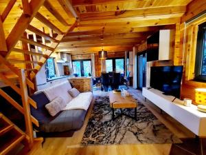 a large living room with a couch and a table at Gîte le Chalet Aura & jacuzzi in Abreschviller