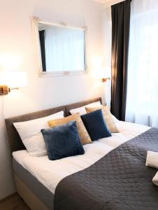 een slaapkamer met een bed met blauwe en witte kussens bij CentroPark Apartament in Olsztyn