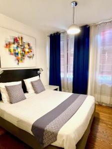 1 dormitorio con 1 cama grande y cortinas azules en Baionakoa Résidence, en Bayona