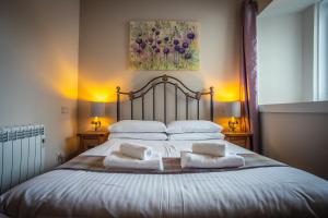 a bedroom with a bed with two towels on it at Douglas House Apartments in Nairn