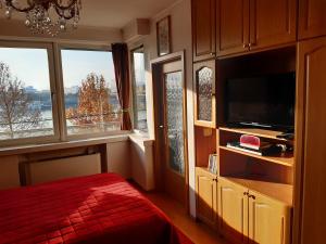 a bedroom with a bed and a tv and windows at Arpadtravel in Budapest
