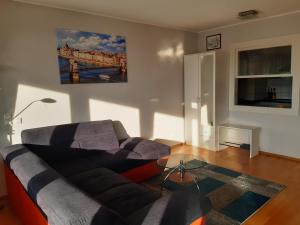 a living room with a couch and a bridge painting on the wall at Arpadtravel in Budapest