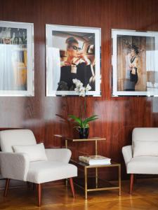 a living room with three pictures on the wall at Casa Cipriani Milano in Milan