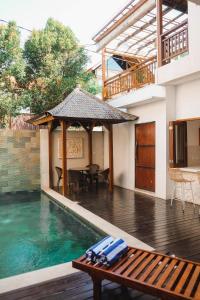 een huis met een zwembad en een houten tafel bij Villa Salaska by Bali Prime Hospitality in Canggu