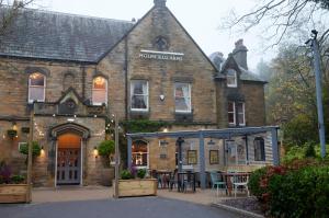 un antiguo edificio de ladrillo con un restaurante delante de él en Holmfield Arms by Greene King Inns, en Wakefield