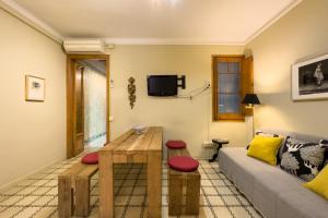 een woonkamer met een bank en een tafel bij ApartEasy - Gracia Apartments in Barcelona