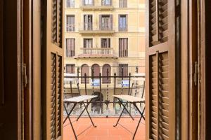 een uitzicht op een gebouw vanuit een open raam bij ApartEasy - Gracia Apartments in Barcelona
